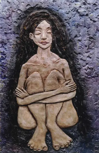 Betongrelief. En naken kvinna sitter med benen böjda och kramar om sina knän. Hon har slutna ögon och långt, mörkt, lockigt hår.